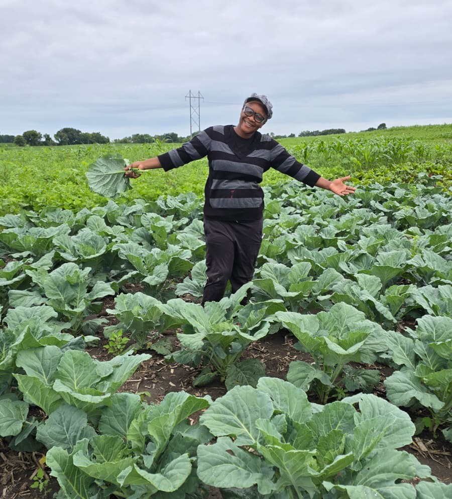 Anita Fondikum standing in a field of cabbage at Shining Lights Farm.